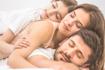 Obraz na płótnie Canvas The happy family sleeping on the bed