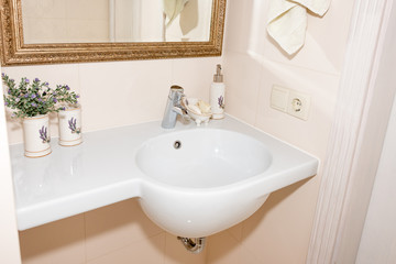 Fragment of a luxury bathroom. Exclusive modern white bathroom with white sink and faucet.