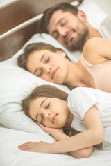 Obraz na płótnie Canvas The family sleeping on the comfortable bed