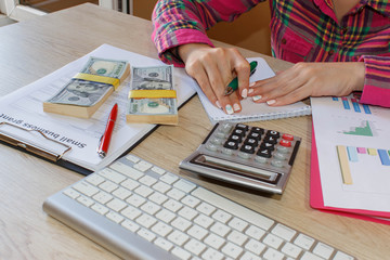 Savings, finances, economy and home concept - Female with calculator, Female holding pens, papers, notes