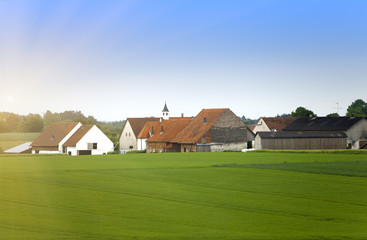 Fototapeta na wymiar rural areas in Germany, Bavaria, with brightly green fields and trees small and.village .