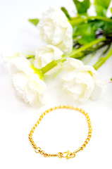 Obraz na płótnie Canvas Gold bracelet isolated on white with flowers