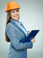 Smiling business woman builder holding clipboard with pen.