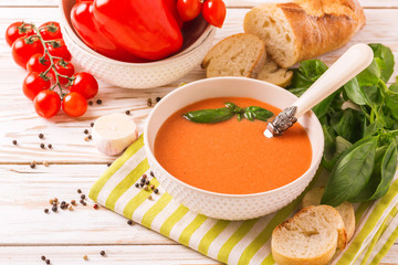 Italian tomato soup gazpacho with basil, tomatoes and baguette