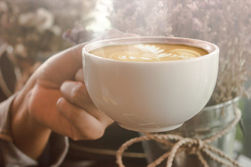 Female hands holding cup in cafe