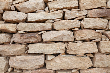 Close-up pattern of natural stones wall in West African village Djiguibombo.