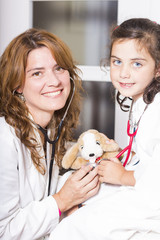 Doctor and child paying with a stuffed animal