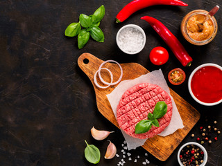 Raw beef meat steak cutlet for burger with spices and vegetables