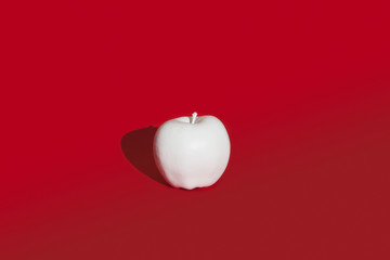 Apple painted white on red background