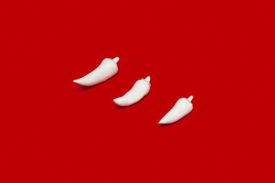 Chillies painted white on red background