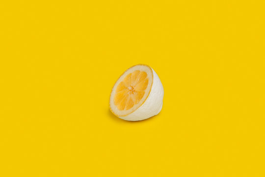 Half a lemon painted white on yellow background