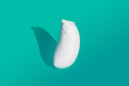 Aubergine painted white on turquoise background