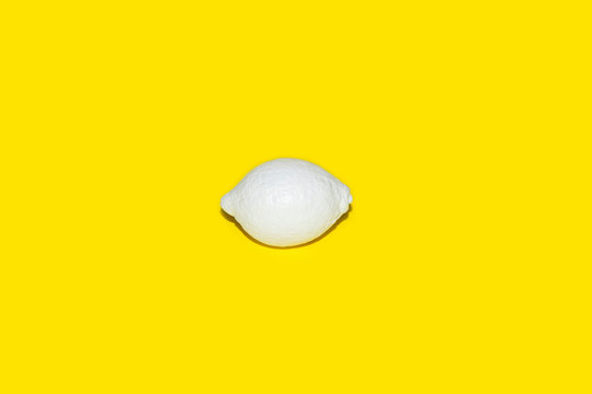 Lemon painted white on yellow background