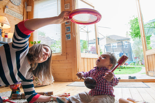 Childminder and baby boy playing with tambourine