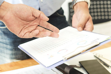 Close-up of businessman explaining a financial plan to colleagues at meeting