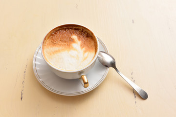 A cup of coffee and a spoon on a vintage table