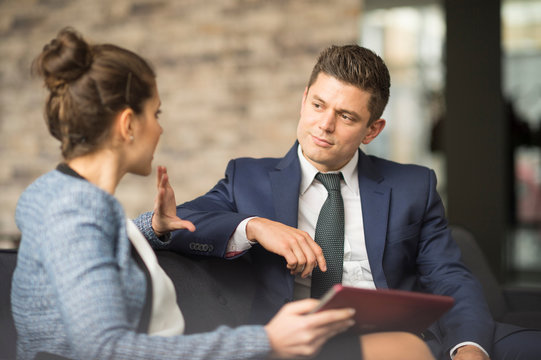 Businessman and woman meeting on office sofa