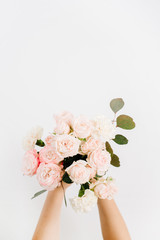 Beautiful pink rose flower and eucalyptus branches bouquet in girls hand isolated on white background. Flat lay, top view. Floral composition