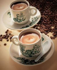 Coffee and tea surrounded by coffee beans
