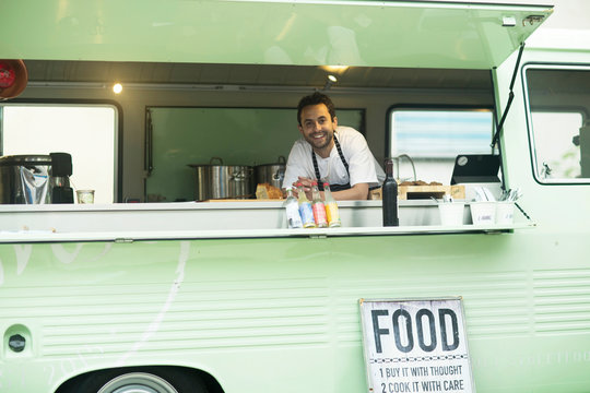 Portrait of small business owner at van food stall hatch