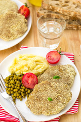 Schnitzel from beef served with mashed potatoes and green beans