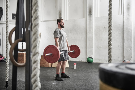 Man lifting barbell in cross training gym