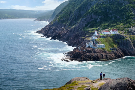 Couple looking out from coastal cliff, St John's, Newfoundland, Canada