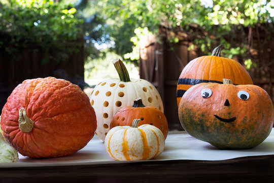 Smiley face and carved pumpkins on garden table