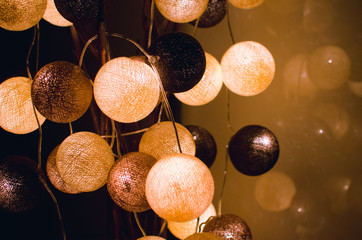 Cotton light balls shining in the dark in a home interior. Creative decoration.