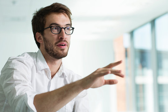 Portrait of businessman, hand raised in conversation