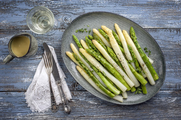 Boiled green and white Asparagus as top view on a plate