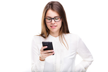 Portrait happy, smiling woman texting on her smart phone, isolated white background. Communication concept. Internet, phone addiction