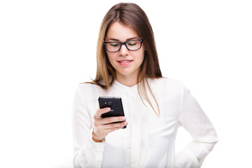 Fototapeta premium Portrait happy, smiling woman texting on her smart phone, isolated white background. Communication concept. Internet, phone addiction