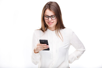 Portrait happy, smiling woman texting on her smart phone, isolated white background. Communication concept. Internet, phone addiction