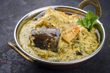 Traditional Indian Vegetable Curry with Sweet Potatoes and Eggplant as close-up in a Korai