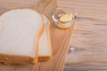 Slices bread with butter on wooden table