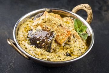 Traditional Indian Vegetable Curry with Sweet Potatoes and Eggplant as close-up in a Korai