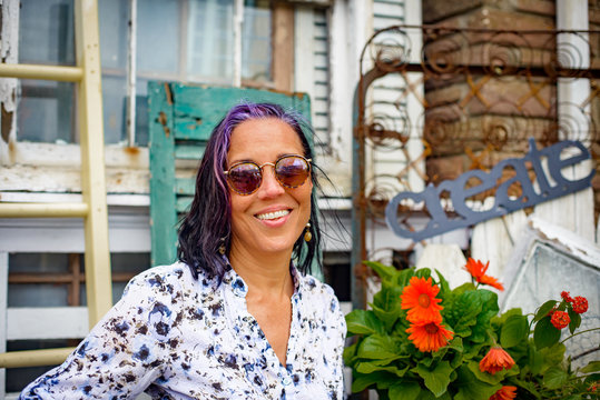 Portrait of female shop keeper outside front porch shabby chic shop