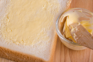 Slices bread with butter on wooden table