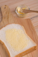 Slices bread with butter on wooden table