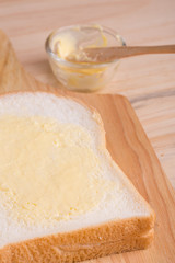 Slices bread with butter on wooden table