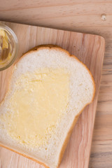 Slices bread with butter on wooden table
