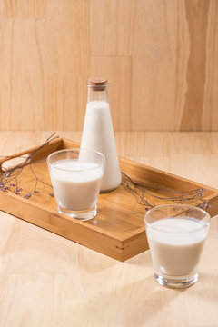 Dairy products. A bottle of milk and glass of milk on a wooden table.