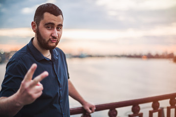 Portrait of happy brutal man showing two fingers