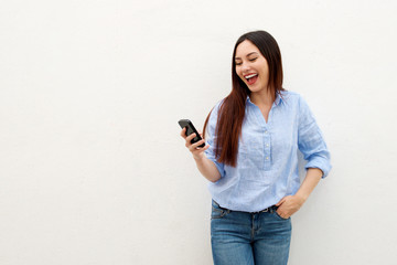 Beautiful woman holding mobile phone and laughing