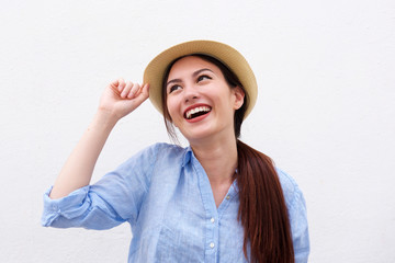 Close up fashionable young woman smiling with hand to hat