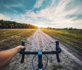 Fototapeta na wymiar cyclist rides on the meadov dirt road on a Cyclocross bike.