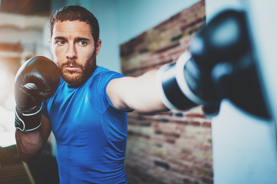 Young Man Athlete Boxing Workout In Fitness Gym On Blurred Background.Athletic Man Training Hard.Kick Boxing Concept.Horizontal.