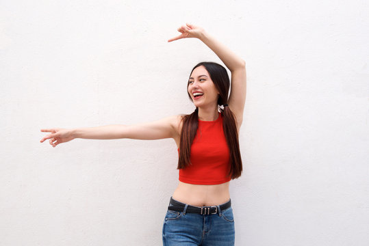 Happy Woman Indicating To The Side With Arms Outstretched