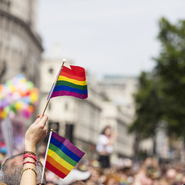 A spectator waves a gay rainbow flag at an LGBT gay pride march in London